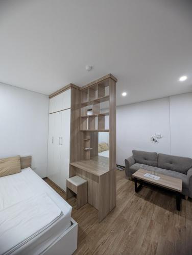 a bedroom with a bed and a couch at Era Apartment Lac Long Quan in Hanoi