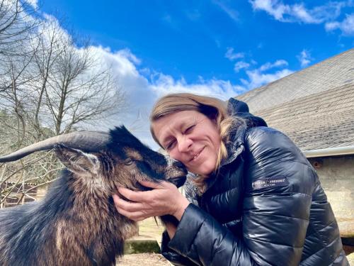 a woman is hugging a goat at Die Alm in Schöllbüchl, Privatzimmer in St. Martin