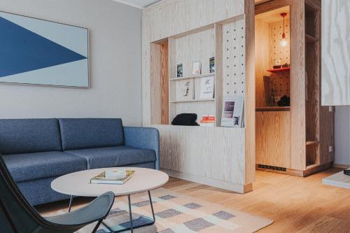 a living room with a blue couch and a table at Silt & Sand Langeoog in Langeoog