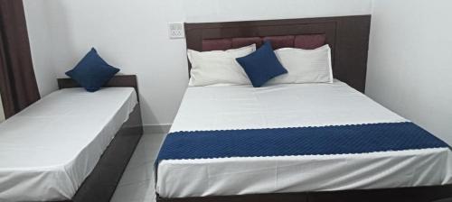 a bedroom with two beds with blue and white pillows at Heart Heaven Home Stay in Nākuri