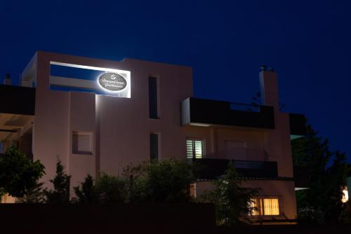 a building with a sign on the side of it at night at DreamCoast Apartments I in Artemida