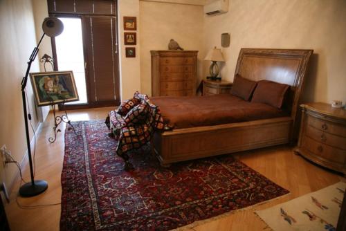 1 dormitorio con cama, lámpara y alfombra en Near the Opera, en Itʼkhvisi