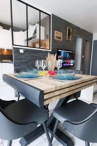 une table en bois avec deux chaises et une table avec des verres à vin dans l'établissement Le Duplex Preize chez Stéphane et Sabrina, à Troyes