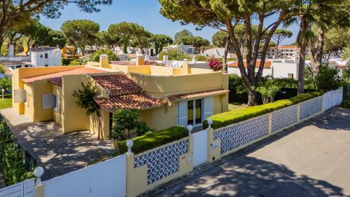 a yellow house with a white fence at Villa Girassol in Vilamoura