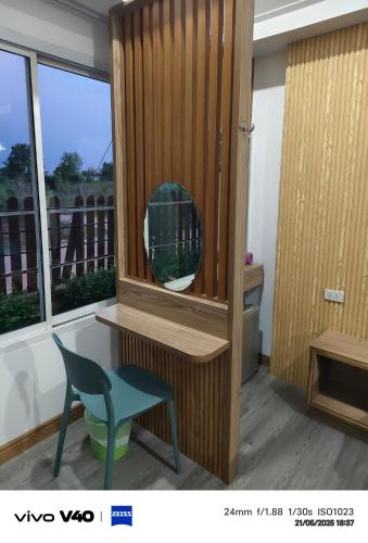 a mirror and a chair in a room with a window at ไดซูแนลรีสอร์ท in Ban Nong Chaeng