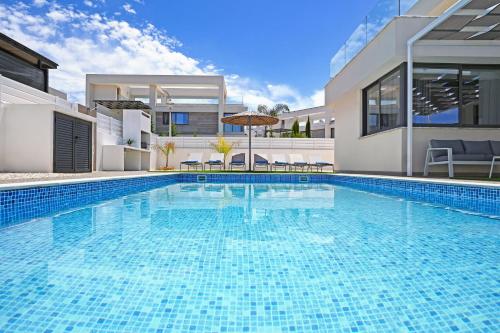 una grande piscina davanti a una casa di Villa Violeta - 3bed Bungalow large pool a Protaras