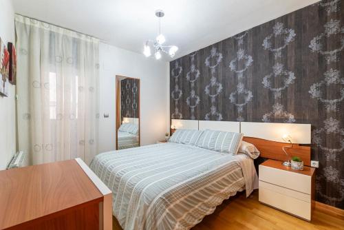 une chambre avec un lit et une peinture murale dans l'établissement Apartamento en Delicias 'Hector' - Parking Incluido, à Saragosse