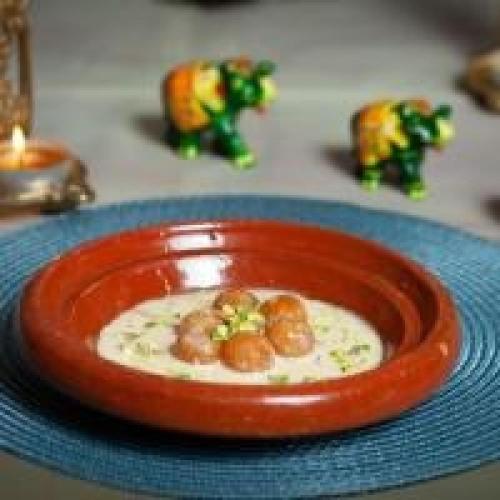 a red bowl of food on a plate on a table at Dancenter Luxury Holiday International Dubai in Dubai