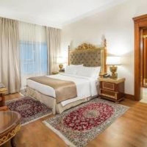 a bedroom with a large white bed and a table at Dancenter Luxury Holiday International Dubai in Dubai