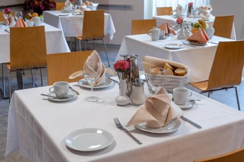 una mesa con manteles y platos blancos. en Hotel Junior Poděbrady, en Poděbrady