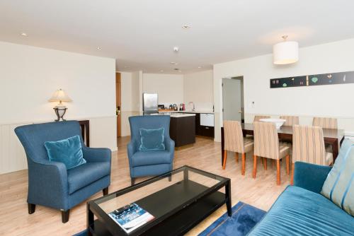 a living room with a couch and chairs and a table at Scenic Hotel Southern Cross in Dunedin