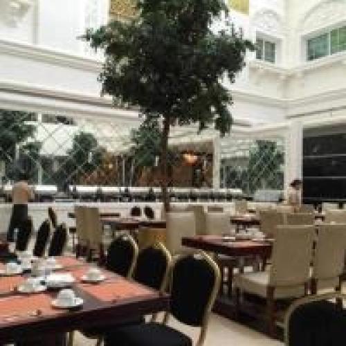 a restaurant with tables and chairs and a tree at Dancenter Luxury Holiday International Dubai in Dubai