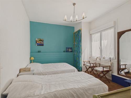 une chambre avec deux lits et un mur bleu dans l'établissement 200 m de la plage - Plein centre - Cour intérieure, à Les Sables-dʼOlonne