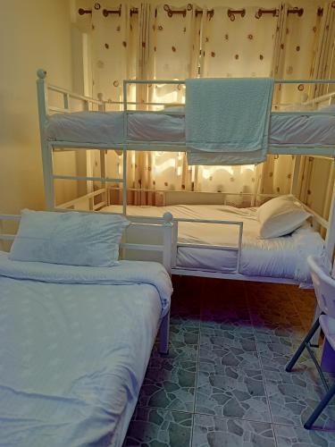 two bunk beds sitting in a room with at Camp William's - A dreamer's paradise in Kiambu in Kanyore