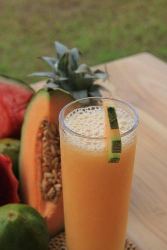 a glass of juice sitting on a table with fruit at Morika Villa in Rua