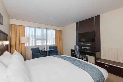 a hotel room with a bed and a television at Scenic Hotel Southern Cross in Dunedin