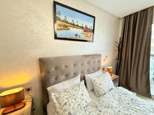Un dormitorio con una cama y un cuadro en la pared. en New Luxury apartment with Style, Balcony and Pool, en Agadir