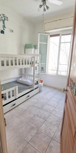 - une chambre avec 2 lits superposés et une grande fenêtre dans l'établissement Appartement au coeur d'Antibes, à Antibes