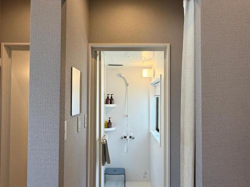 a bathroom with a shower and a toilet in a room at TABISAI HOTEL House 博多 in Fukuoka