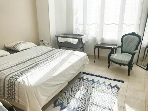 une chambre avec un lit et deux chaises et une fenêtre dans l'établissement Appartement au coeur d'Antibes, à Antibes