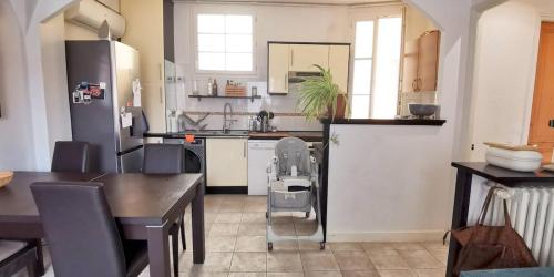 Il comprend une cuisine équipée d'une table et d'un réfrigérateur. dans l'établissement Appartement au coeur d'Antibes, à Antibes