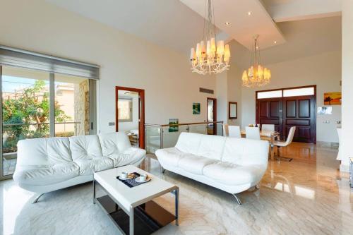 a living room with two white couches and a table at Villa Pandora Limni by Villa Plus in Mavroli
