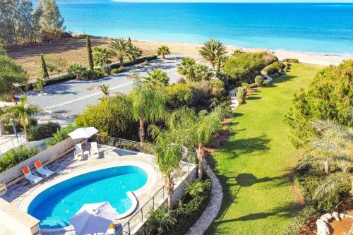 an aerial view of a swimming pool and the beach at Villa Pandora Limni by Villa Plus in Mavroli