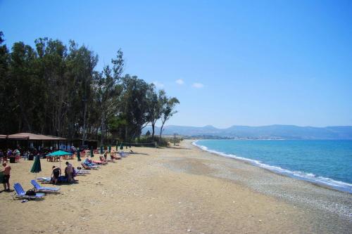 a beach with a bunch of chairs and people on it at Villa Pandora Limni by Villa Plus in Mavroli