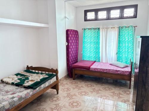 une chambre avec deux lits et une fenêtre dans l'établissement Maadhuban Home Stay, à Dibrugarh