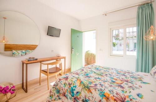 a bedroom with a bed and a desk and a mirror at Fortuna in Los Caños de Meca