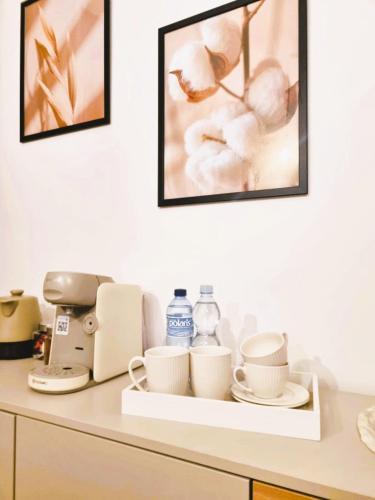 a shelf with cups and coffee cups on a counter at Good Vibes HOSTEL in Częstochowa