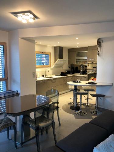 une cuisine et une salle à manger avec tables et chaises dans l'établissement Appartement T2 78 m2 le Saint Elois 1 chambre terrasse et garage, à Aix-les-Bains