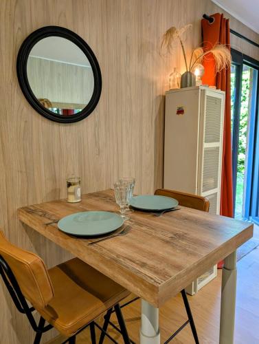 - une table à manger avec des chaises et un miroir dans l'établissement Studio en bois, confort et modernité, à Saint-Brévin-les-Pins