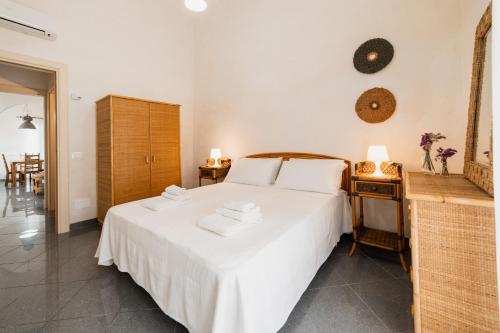 a bedroom with a white bed with two towels on it at CASA PAPADIA in Uggiano la Chiesa