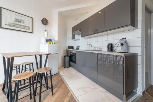 une cuisine avec un comptoir et un bar avec des tabourets dans l'établissement Very nice apartment in downtown Mulhouse Parking, à Mulhouse