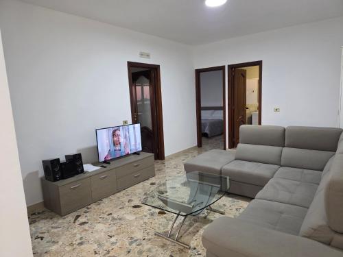 Una sala de estar con un sofá y un televisor. en Parco degli Ulivi, en Terlizzi