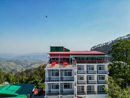 a white building with a red roof on top of it at Ai 360 Degree Hotel Lansdowne in Lansdowne