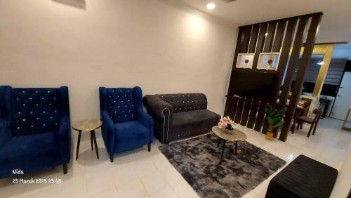 a living room with two blue chairs and a couch at DE LISA HOMESTAY WAKAF BHARu in Wakaf Baharu