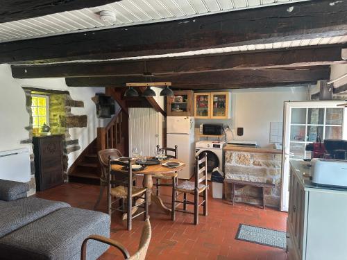 une cuisine et une salle à manger avec une table et des chaises dans l'établissement Belle maison au calme - accès GR34, à Crozon
