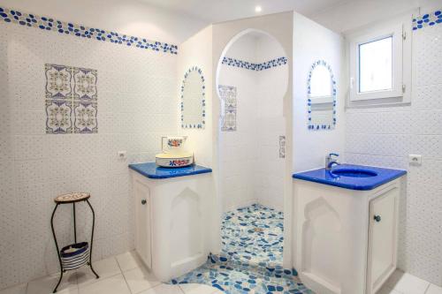 La salle de bains est pourvue d'un lavabo et d'un sol bleu et blanc. dans l'établissement Villa Les Capucines by Villa Plus, à La Garde