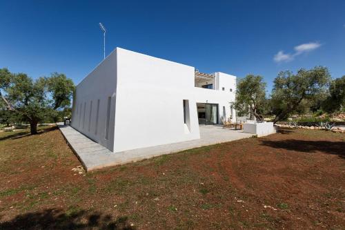 a white house in a field with a yard at Villa Libe by Perle di Puglia in Specchiolla 