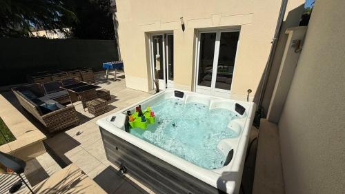 Una bañera con botellas en un patio. en Magnifique Villa avec Spa à COMPIEGNE - Beautiful villa with hot tub, Compiegne, en Compiègne