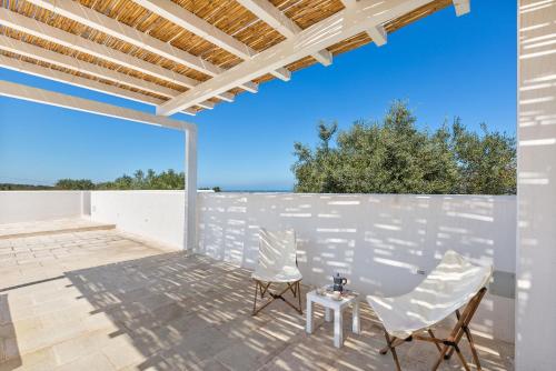 a patio with two chairs and a table at Villa Libe by Perle di Puglia in Specchiolla 
