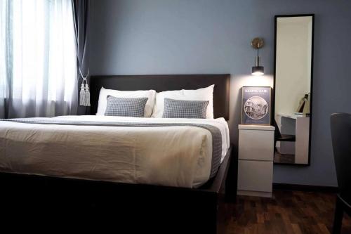 a bedroom with a large bed and a mirror at Heritage Collection on Boon Tat in Singapore