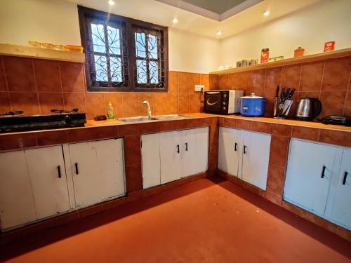 a kitchen with white cabinets and a sink at UNIQ Indurannavila in Ahangama