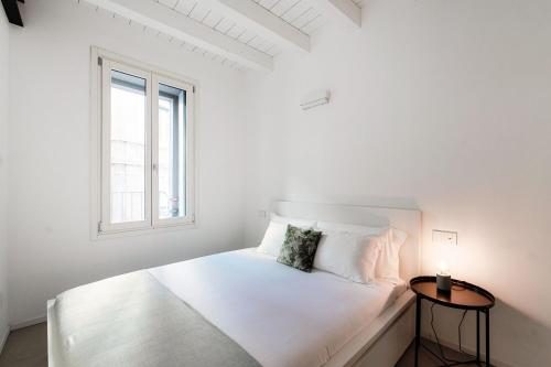 a white bedroom with a white bed and a window at Como Lago Apartment by Quokka 360 - Close to the Lake and Train Station in Como