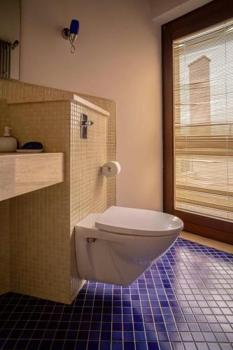 a bathroom with a toilet and a blue tiled floor at Sammit holiday home in Michelica