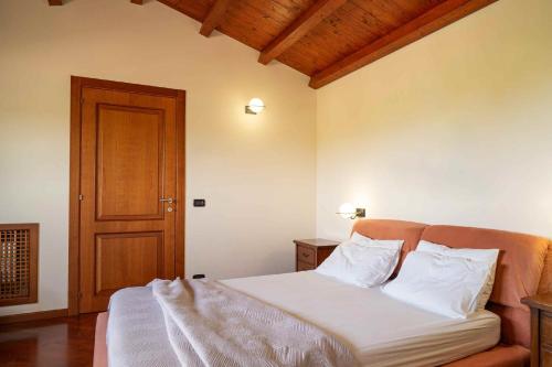 a bedroom with a bed with white sheets and a wooden door at Sammit holiday home in Michelica
