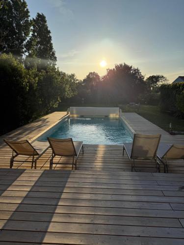- un groupe de chaises assises sur une terrasse à côté d'une piscine dans l'établissement Maison familiale piscine chauffée Jardin d'Océan, à Bretignolles-sur-Mer