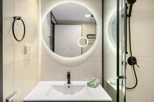 a bathroom with a sink and a mirror at Red Canyon Spa Cozy Garden Stay by Sea N' Rent in Eilat
